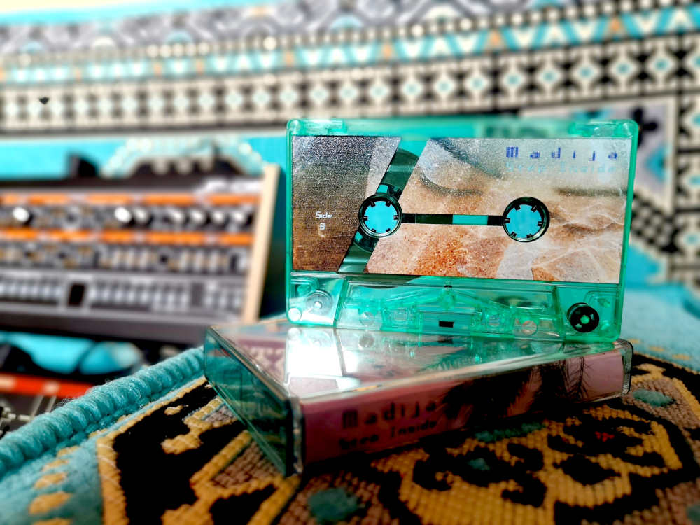 Album cassette in front of roland jupiter 8 synth